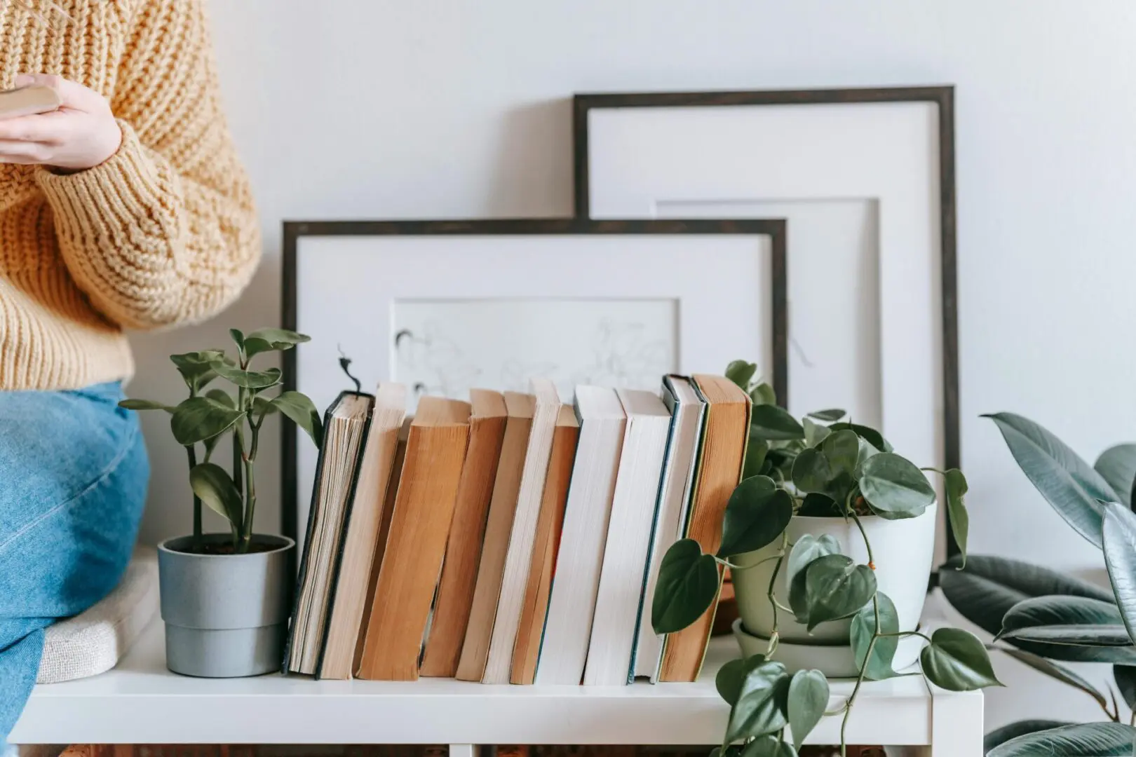 A table with some books and plants on it